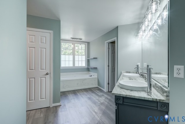 Dual vanity with oval vessel sinks, a large mirror, and a contemporary lighting fixture