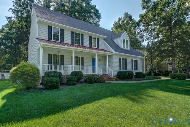 Two-story residence featuring light-colored siding and a covered front porch with white railings