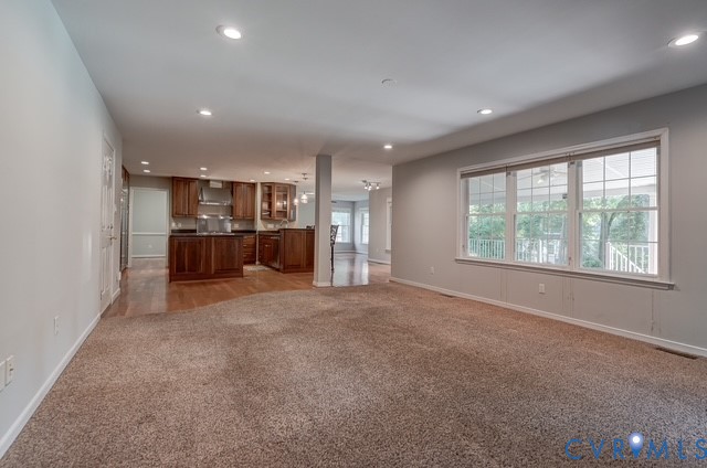 Recessed lighting illuminates the open-concept space featuring carpeting and wood-finish flooring