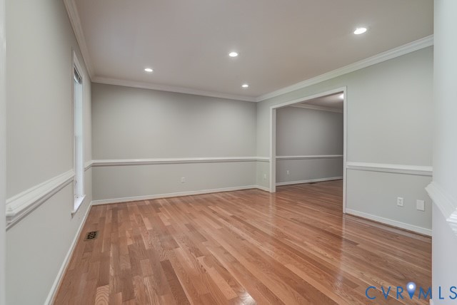 Front Living Room - Hardwood flooring, recessed lighting, crown molding, chair rail molding, and a cased opening