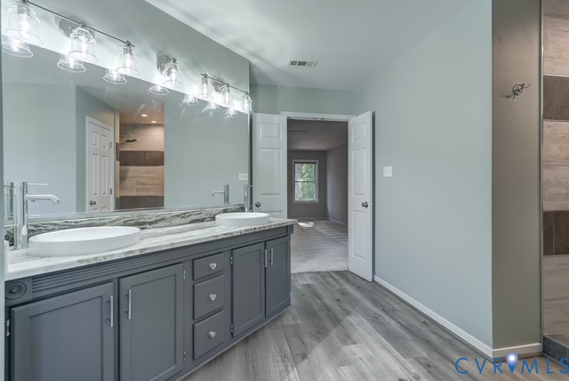 Double vanity with vessel sinks, polished chrome faucets, a full-width mirror, and overhead linear lighting