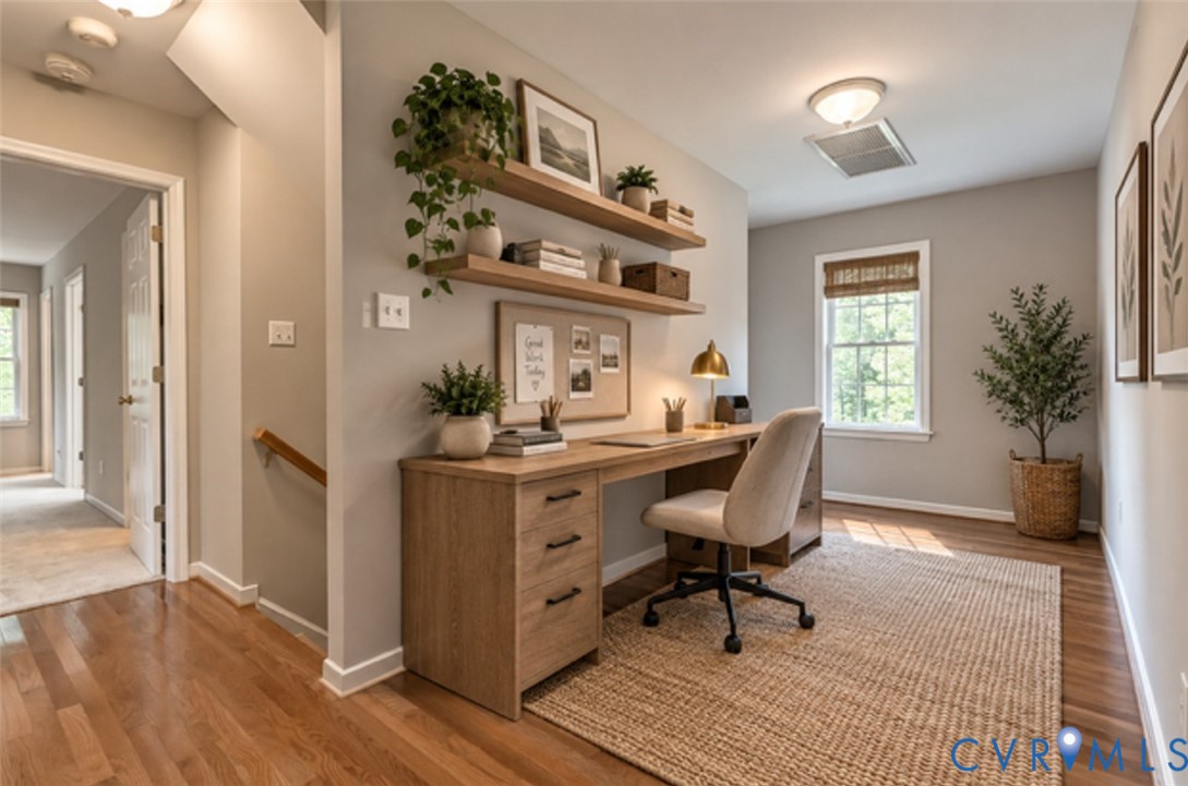 Hardwood flooring throughout, a built-in wood-finish desk, and floating wood shelves
