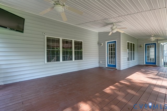 Expansive covered deck with ceiling fans, recessed lighting, and multiple access doors