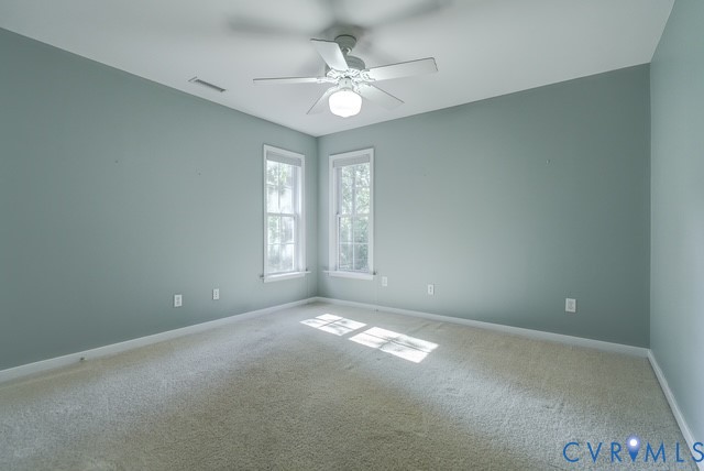 Carpeted room with two windows and a ceiling fan