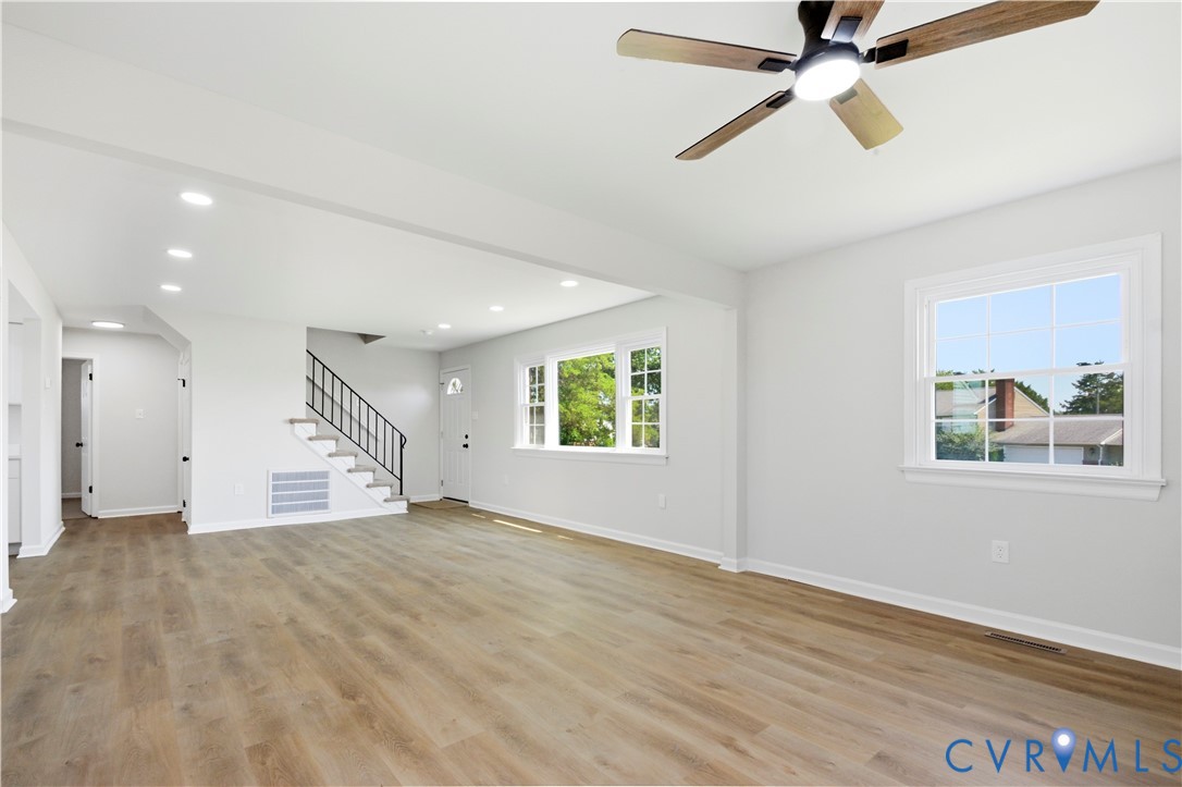 Open-concept living space featuring wood-finish flooring, recessed lighting, and a ceiling fan
