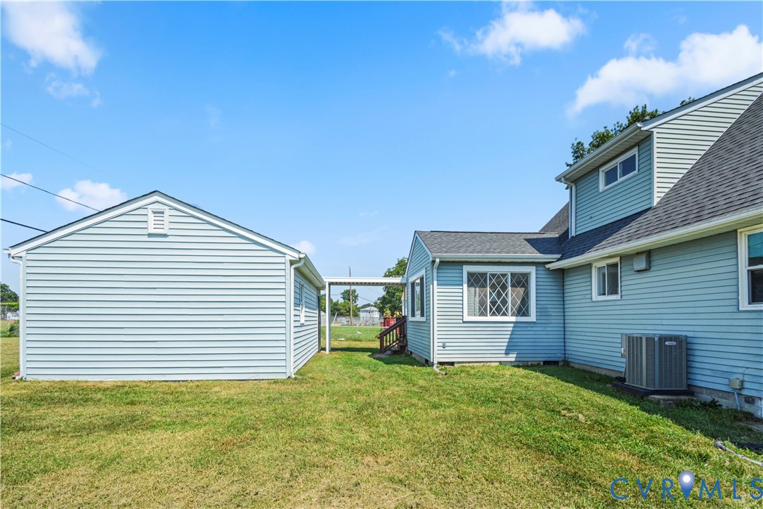 Detached garage with horizontal siding, a covered walkway, and a sloped roof