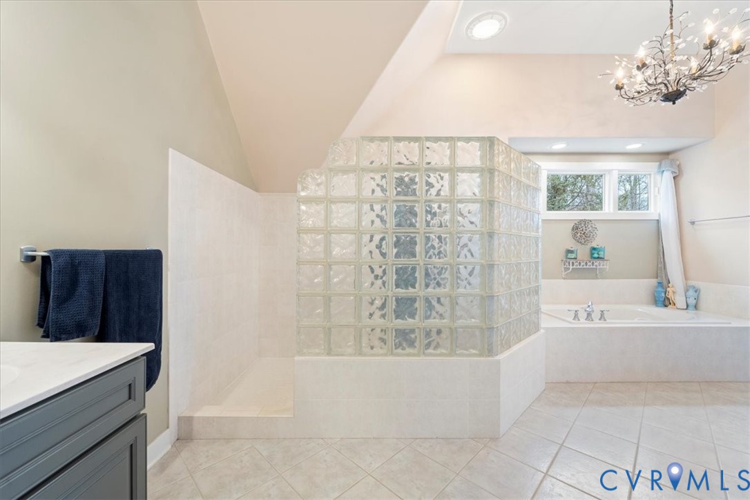 Glass block shower enclosure, built-in soaking tub, dual windows, and recessed lighting