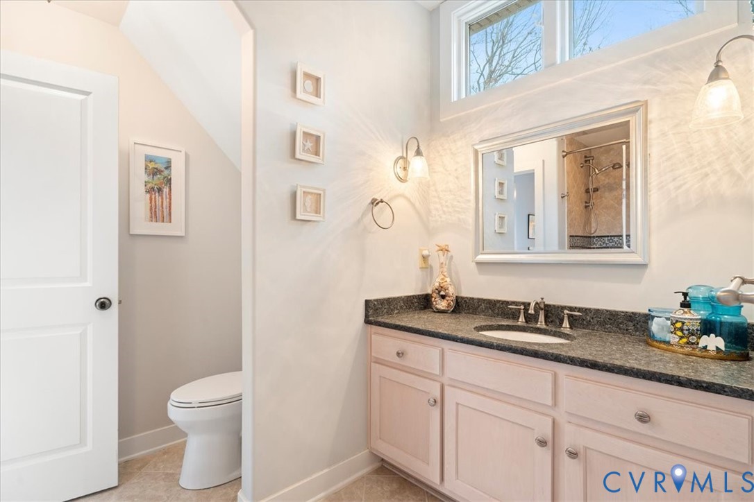 Single vanity with a dark countertop and integrated sink