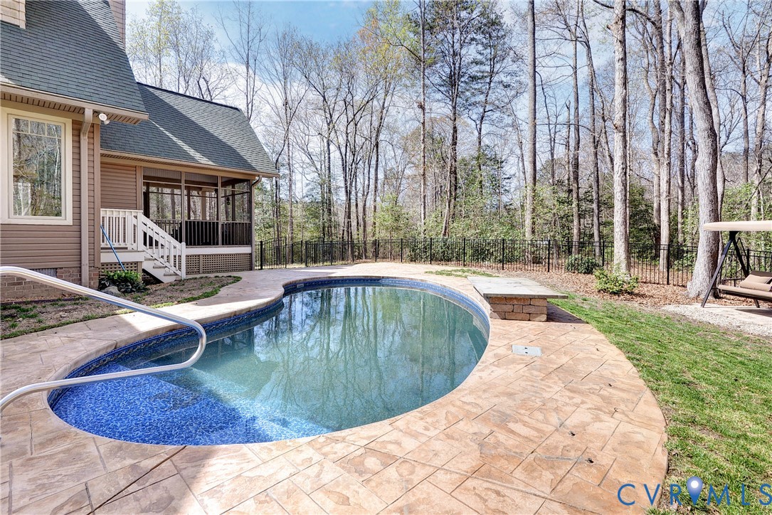 swimming pool with patterned tile interior, stamped concrete surround, and a screened porch