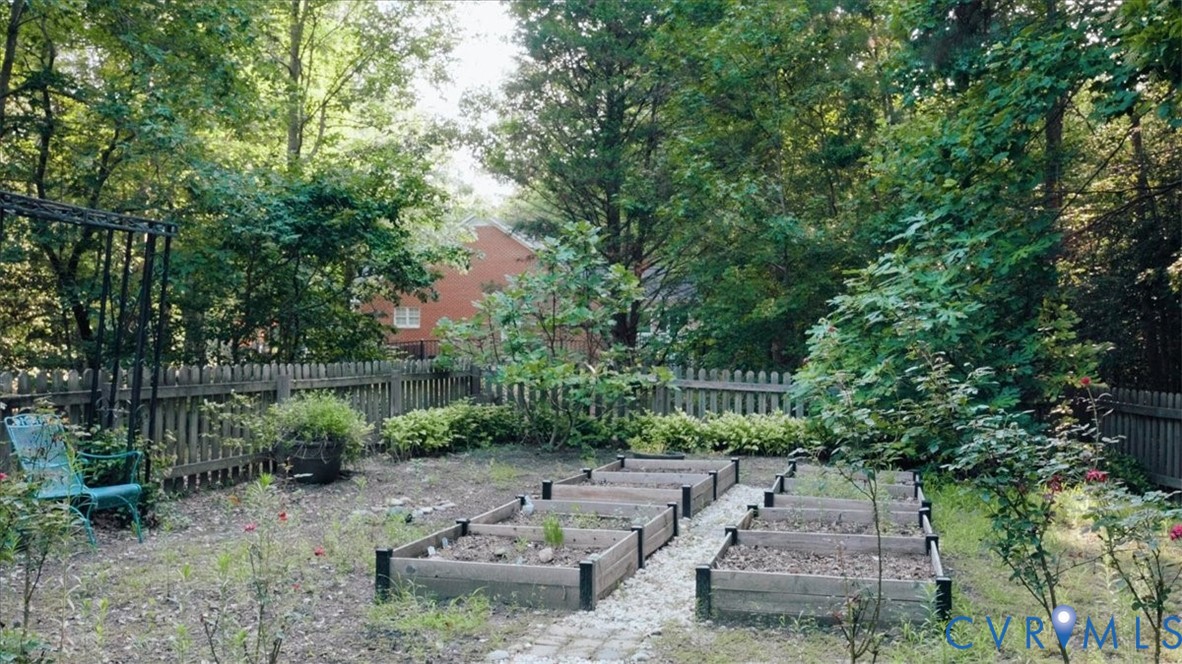 Expansive backyard featuring a wood picket fence, and mature trees. Garden