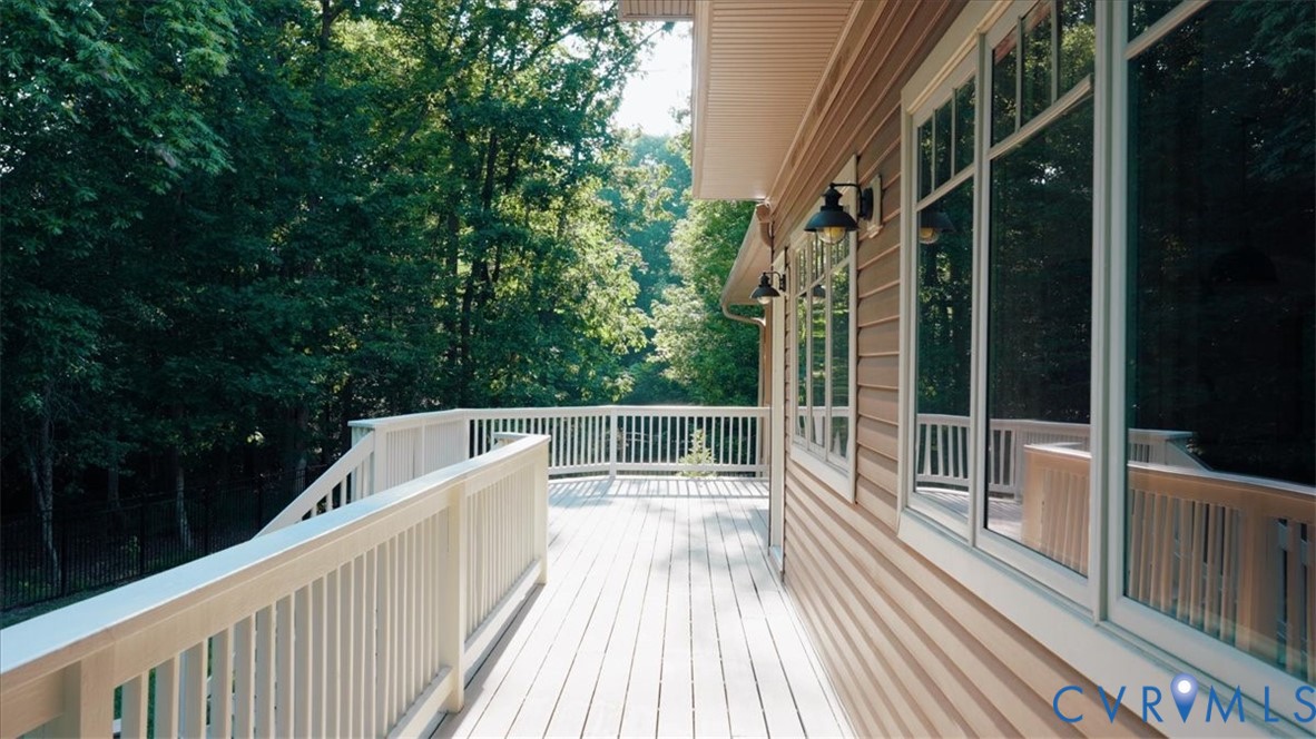 Expansive outdoor deck with a white railing system, featuring a light wood-finish surface