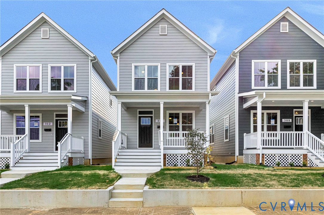 Classic Colonial-style homes featuring crisp white siding, pitched gable roofs with dormer windows, and front-facing porches with white railings