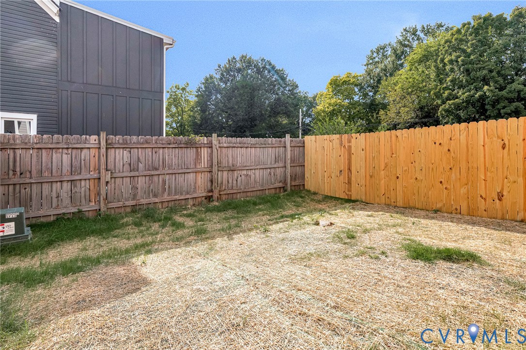 Fenced backyard with a blend of weathered and new wood fencing