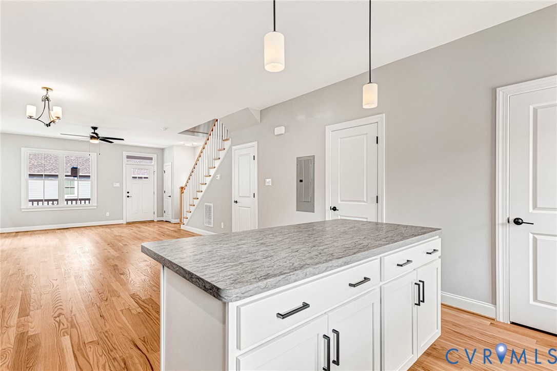 Kitchen island with a light-toned countertop and white cabinetry