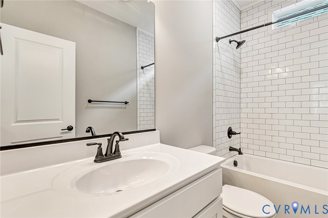 White subway tile shower surround with a built-in tub and dark-bronze fixtures