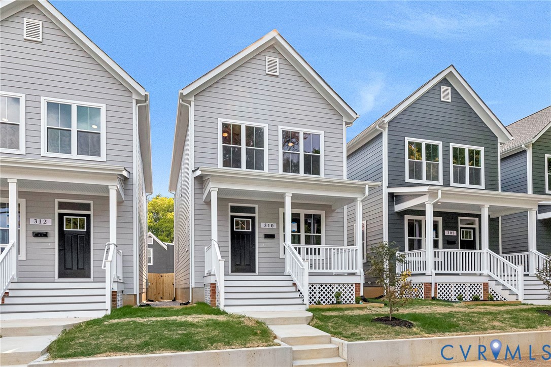 Gray siding exterior with white trim, a covered front porch, white railings, and a dark entry door Gray siding exterior with white trim, a covered front porch, white railings, and a dark entry door