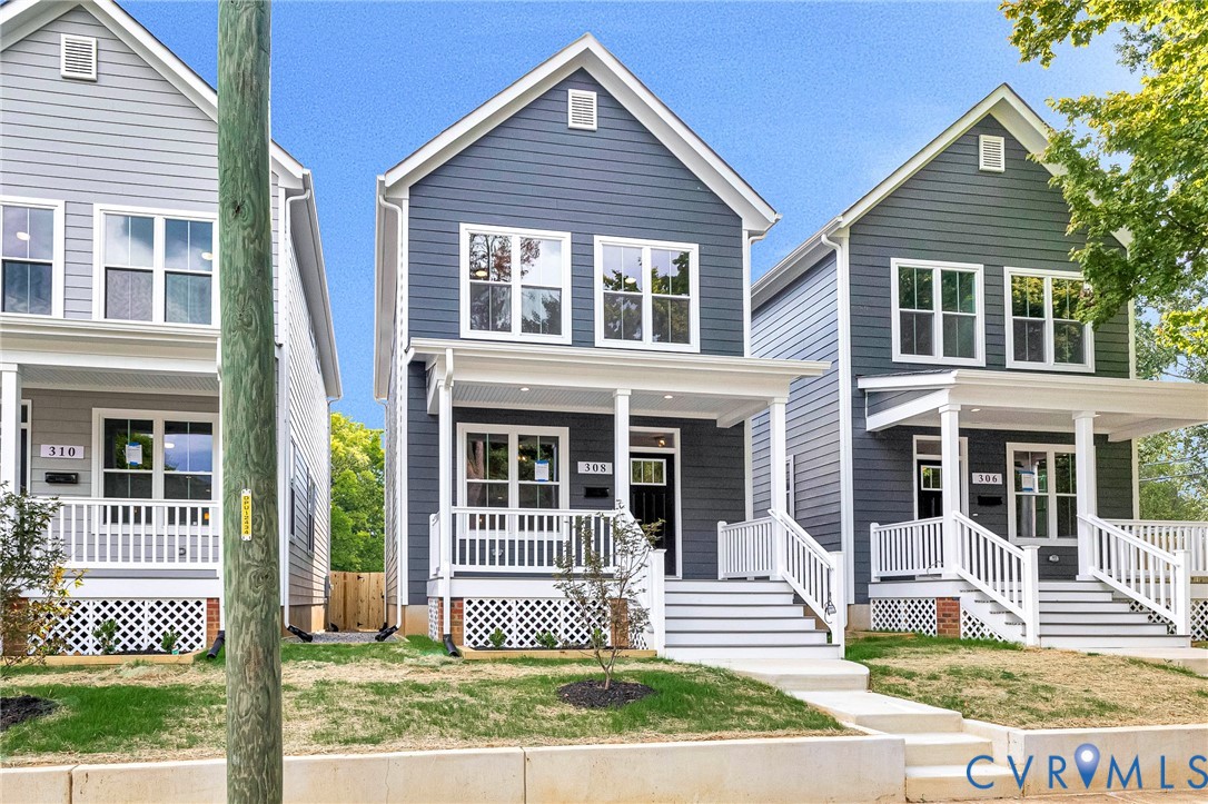 Contemporary home featuring gray siding, a covered front porch with white railings, and multiple double-hung windows