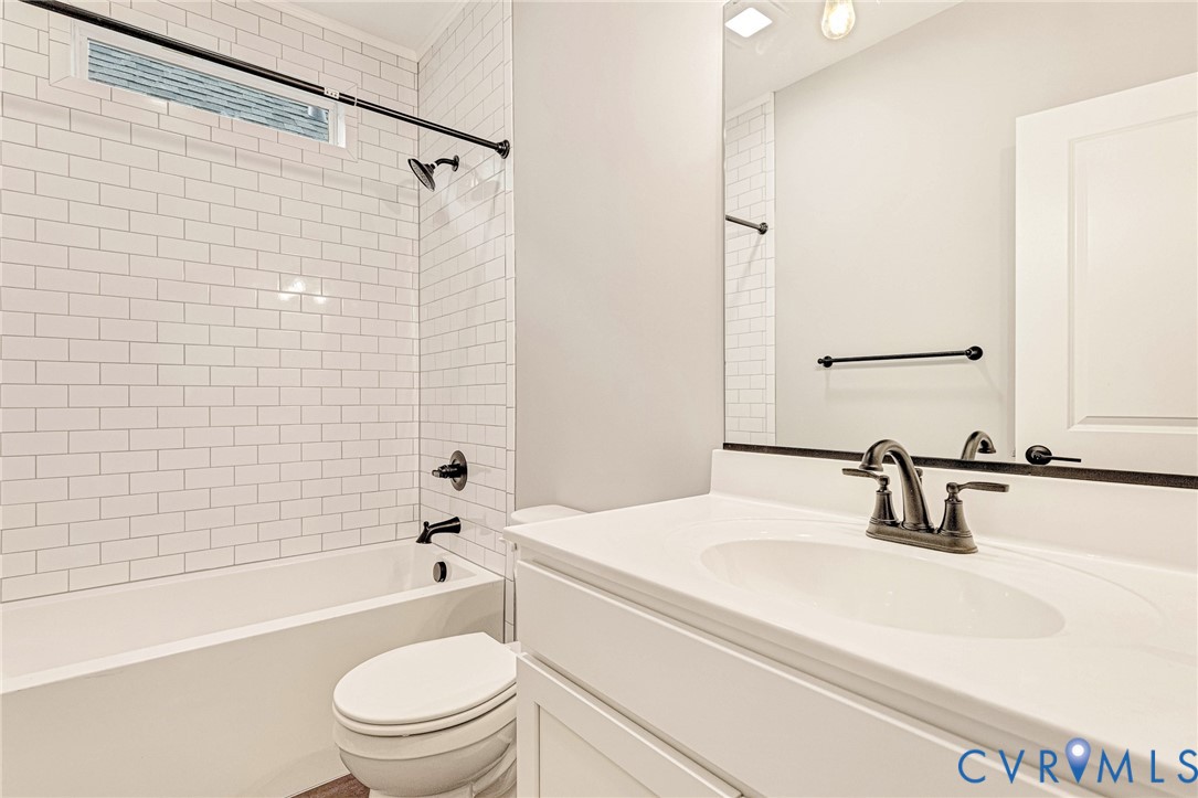 White subway tile shower surround with a fixed showerhead and tub filler