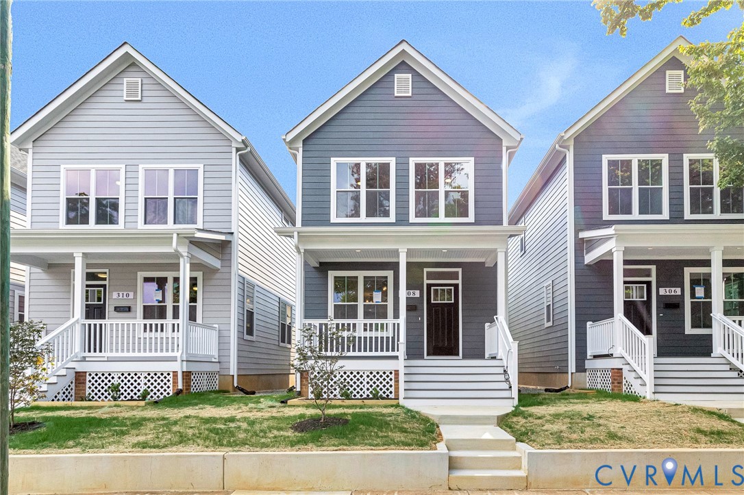 Siding exterior featuring a front porch with white railings and columns, a dark panel door with decorative glass, and a manicured lawn Siding exterior featuring a front porch with white railings and columns, a dark panel door with decorative glass, and a manicured lawn