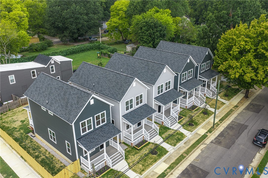 Modern construction with dark gray siding, white trim, and covered front porches