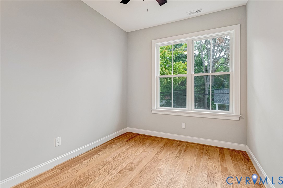 Hardwood flooring, painted walls, white trim, and a ceiling fan