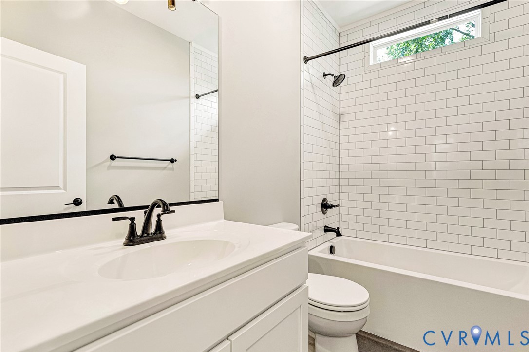 White subway tile shower surround with a built-in tub and matte black fixtures