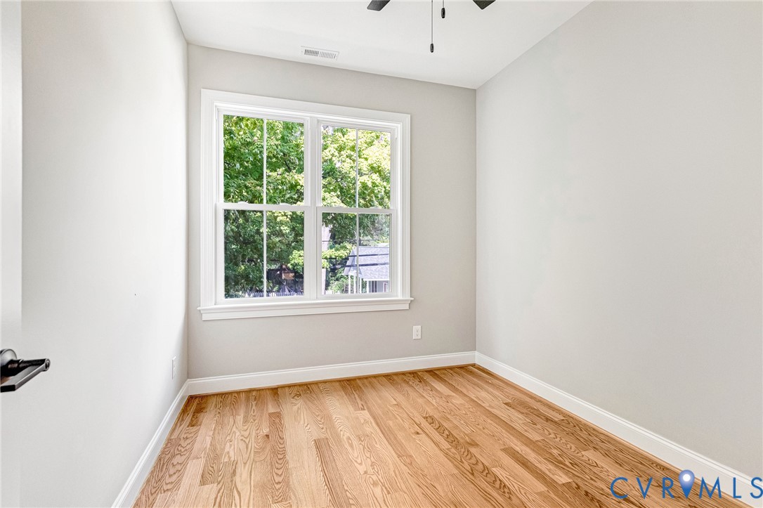 Hardwood flooring, painted walls, white trim, double-hung windows, and a ceiling fan