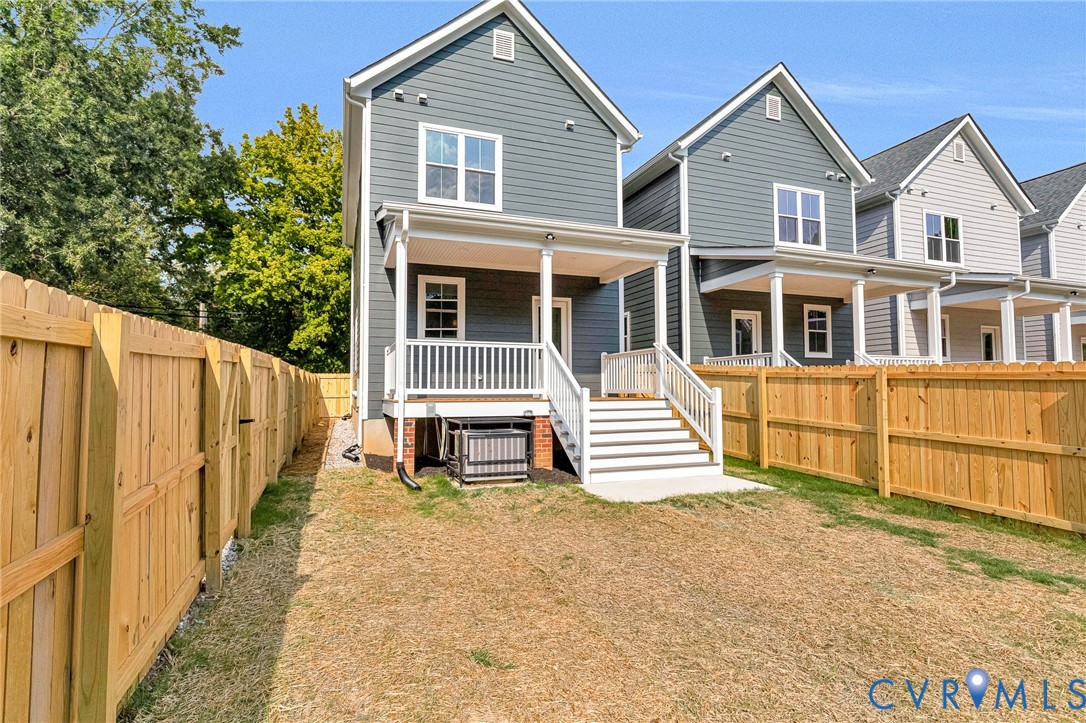 Rear exterior featuring a covered porch, white railing, and steps to grade