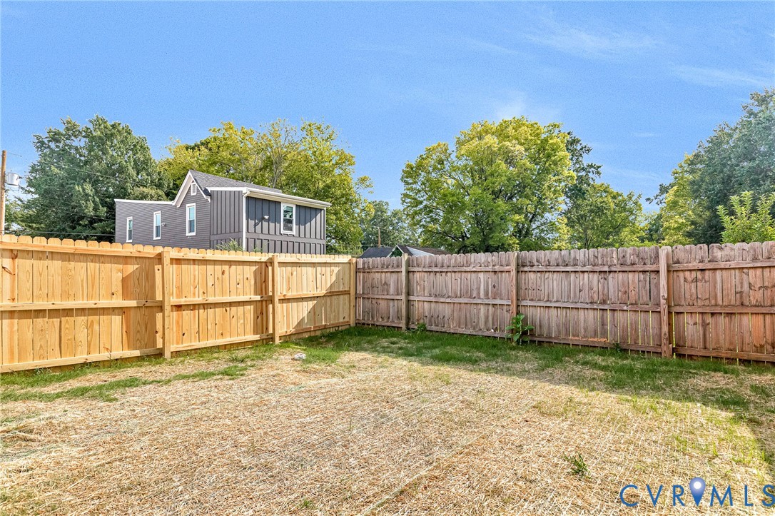 Fenced backyard with natural wood privacy fencing and ample outdoor space