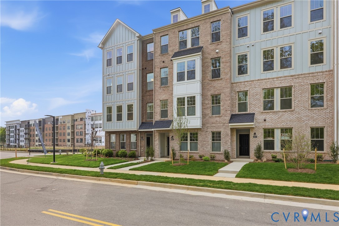 Contemporary multi-story townhome featuring a brick and board-and-batten facade Contemporary multi-story townhome featuring a brick and board-and-batten facade