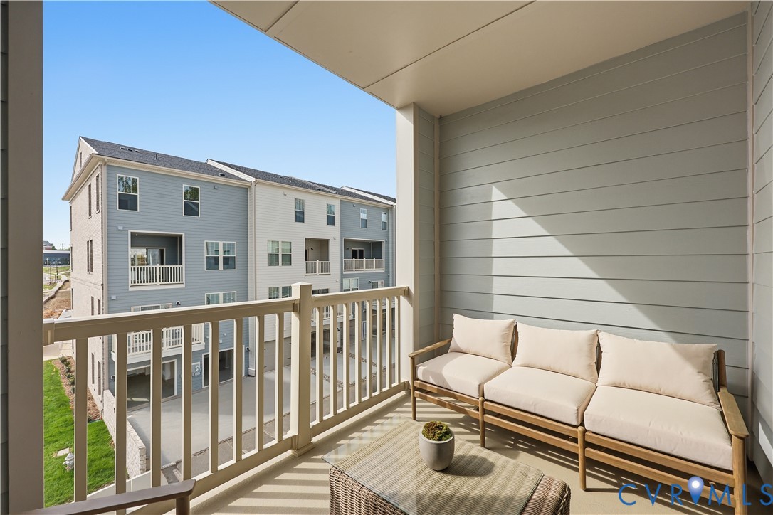 Private balcony featuring a light-toned exterior wall and a sturdy railing Private balcony featuring a light-toned exterior wall and a sturdy railing