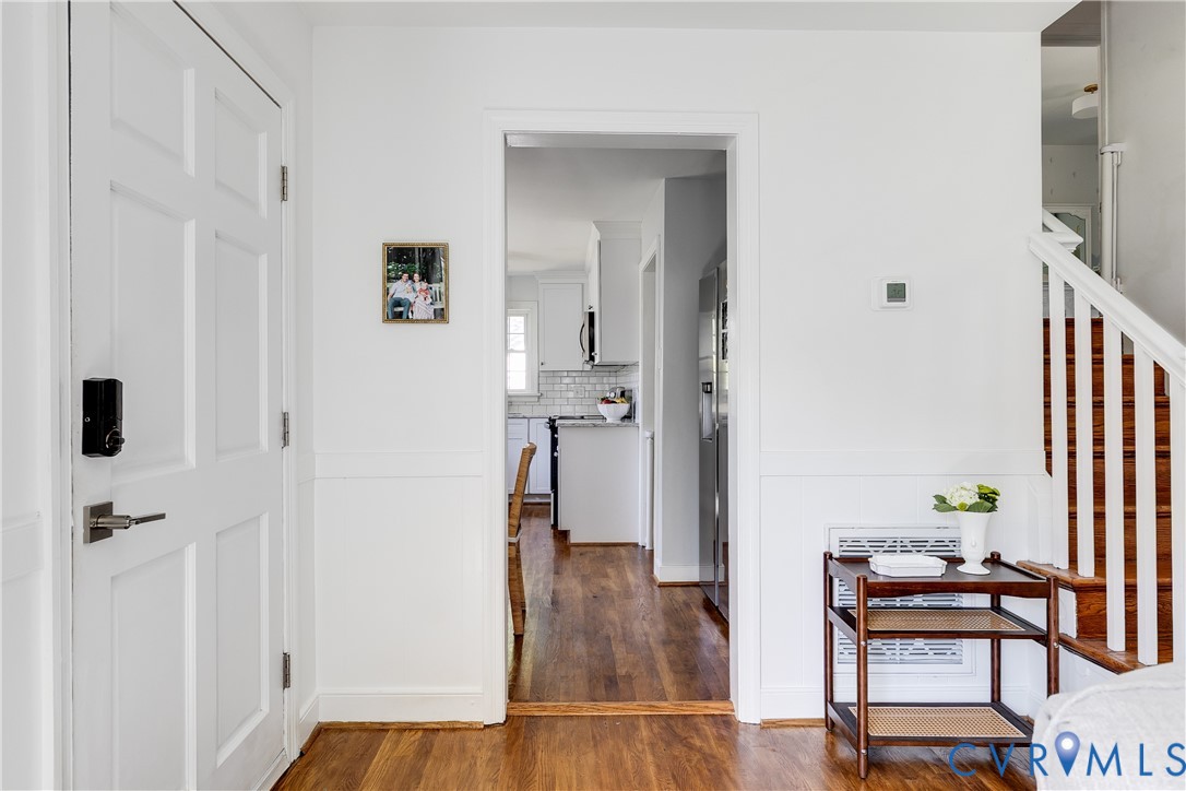 Bright hallway with hardwood flooring, white painted walls, and clean architectural lines
