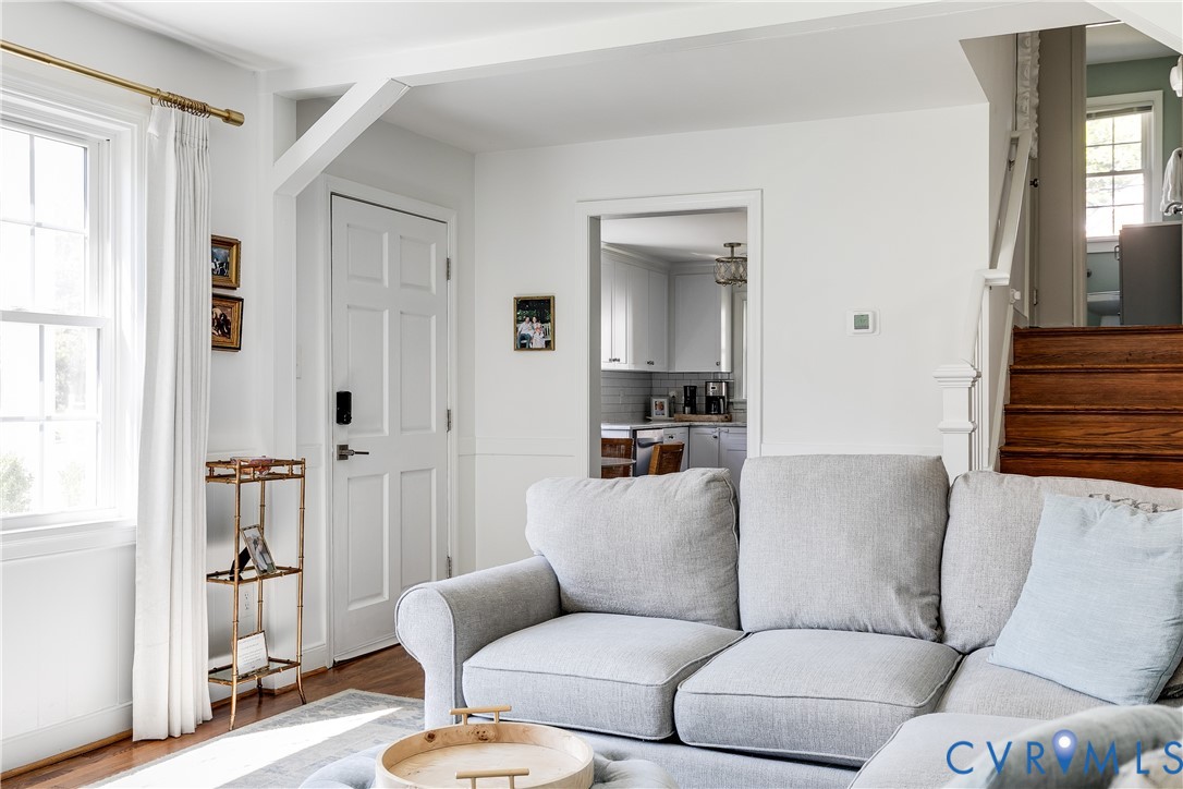 Hardwood flooring, painted paneled interior door, and window with natural light