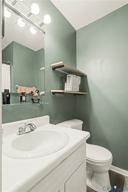 White vanity with integrated sink, chrome faucet, and white toilet