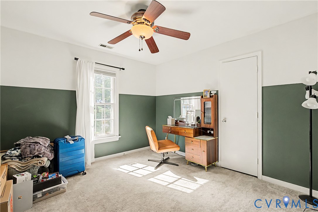 Carpeted room featuring a ceiling fan with light fixture, a single window, and a white door