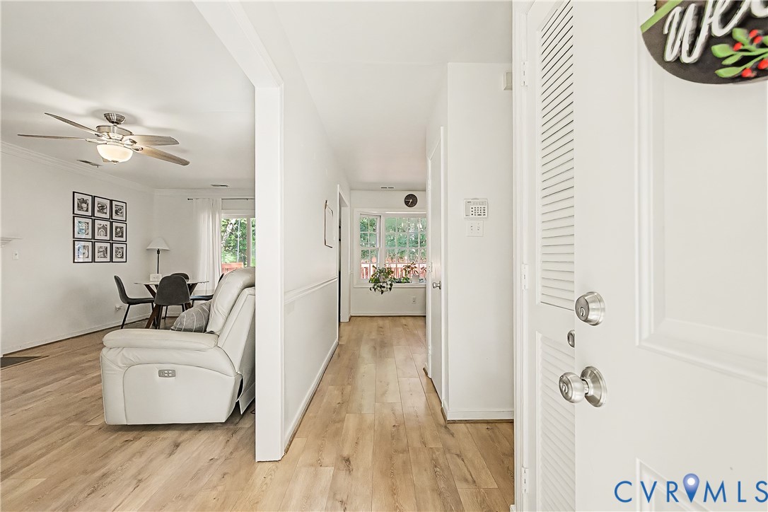 Wood-finish flooring throughout, white interior walls, and crown molding