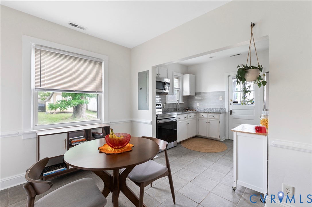 Bright dining area with a double-hung window, white interior trim, and wainscoting Bright dining area with a double-hung window, white interior trim, and wainscoting