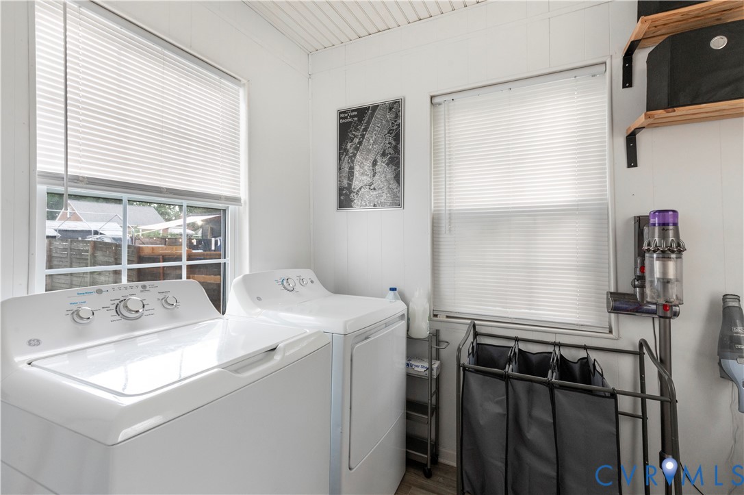 Dedicated laundry area with durable flooring, multiple windows, and a built-in wall shelf Dedicated laundry area with durable flooring, multiple windows, and a built-in wall shelf