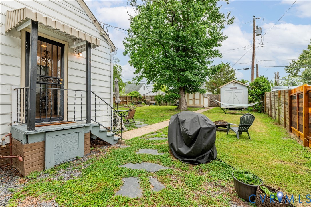 Rear exterior featuring a covered porch, wood siding, and stone pathway