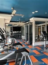 Fitness center featuring a patterned floor, recessed lighting, ceiling fans, and various exercise equipment
