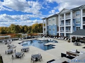 Expansive outdoor amenity space featuring a large swimming pool, surrounding lounge areas, and a structured clubhouse