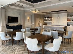 Coffered ceiling details, wall paneling, built-in cabinetry, and wood-finish flooring