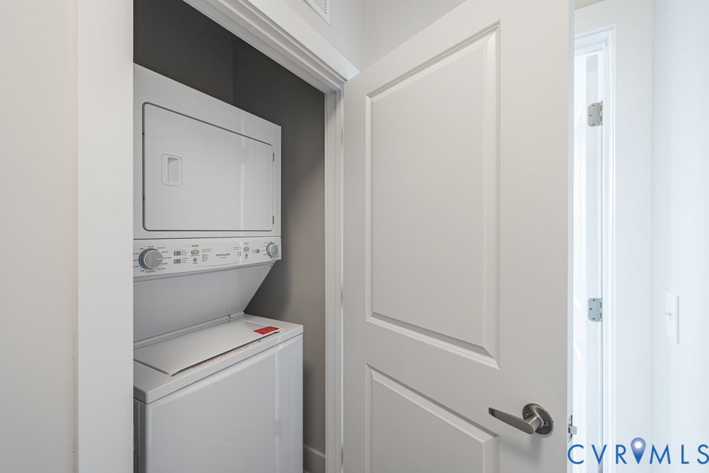 White stacked washer and dryer unit with a paneled door