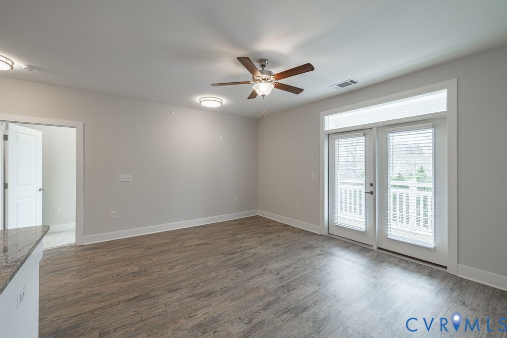 Wood-finish flooring, ceiling fan with integrated lighting, recessed lighting, double doors with transom window, and a built-in countertop