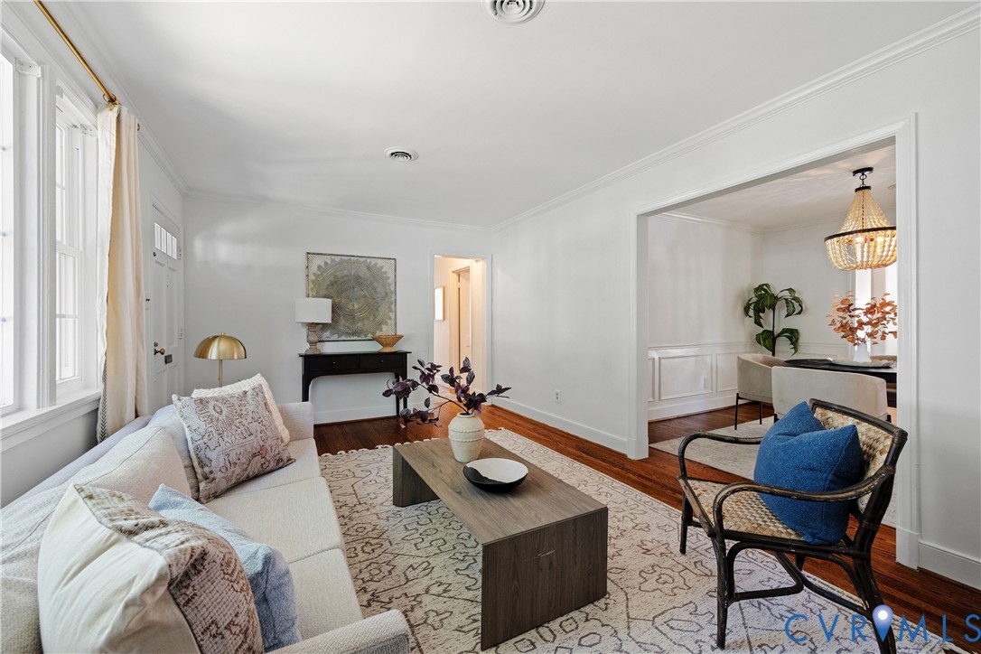 Hardwood flooring, crown molding, and white trim accents