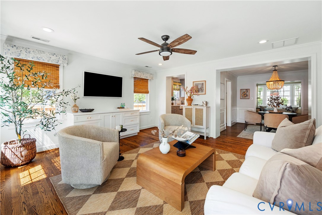 Hardwood flooring, recessed lighting, built-in cabinetry, ceiling fan, and crown molding
