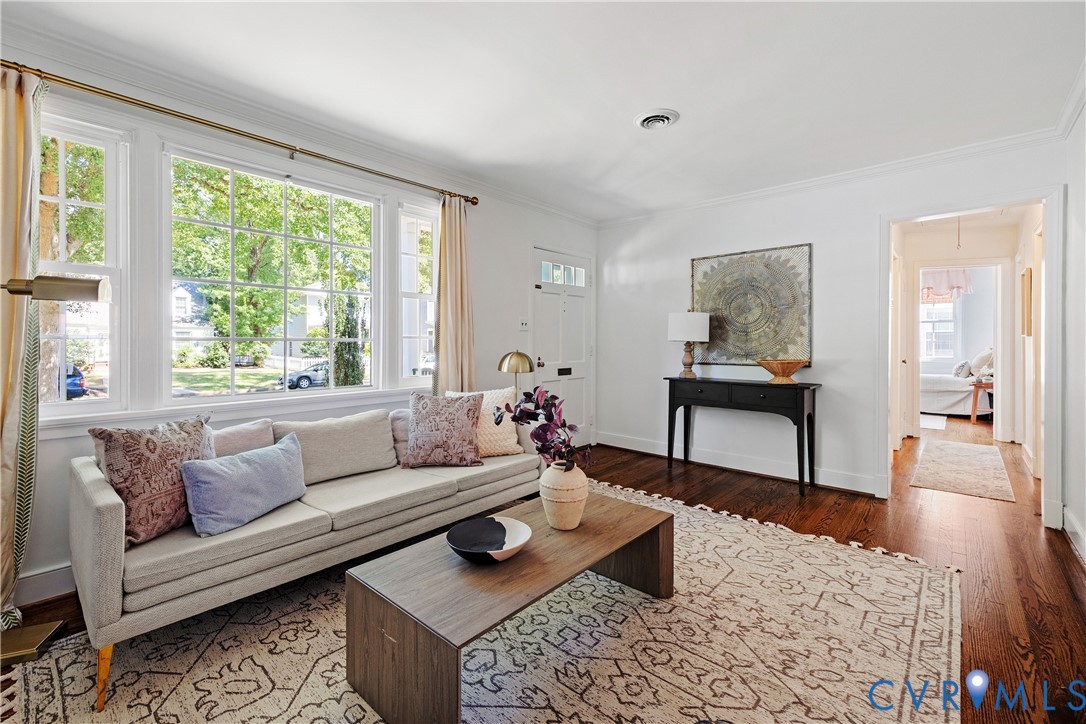 Hardwood flooring, recessed lighting, white trim, crown molding, and large multi-pane windows