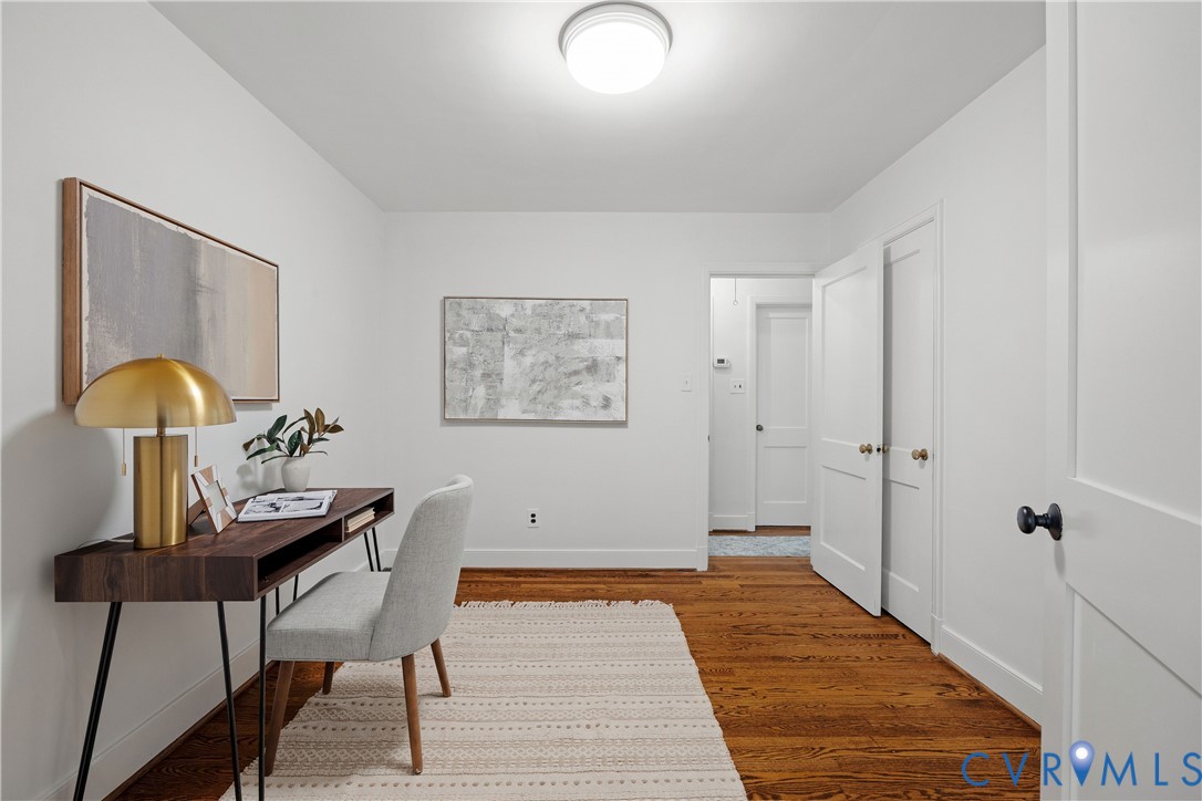 Hardwood flooring, white painted walls, and a flush mount ceiling light