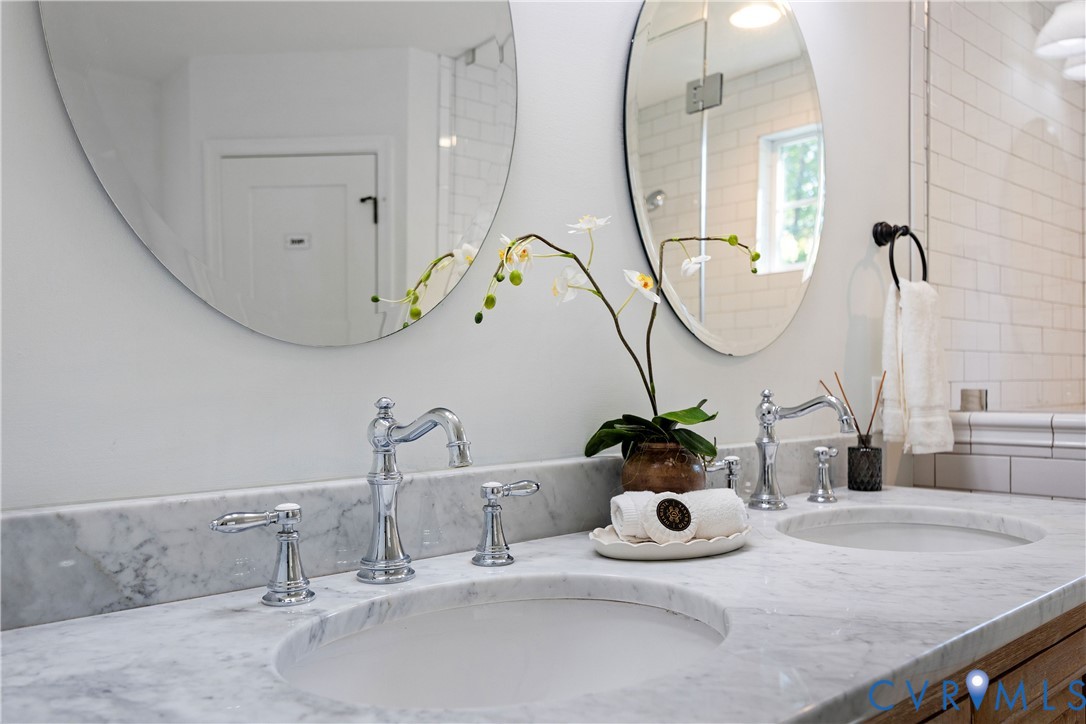 Dual vanity with integrated sinks, marble countertop, and polished chrome fixtures