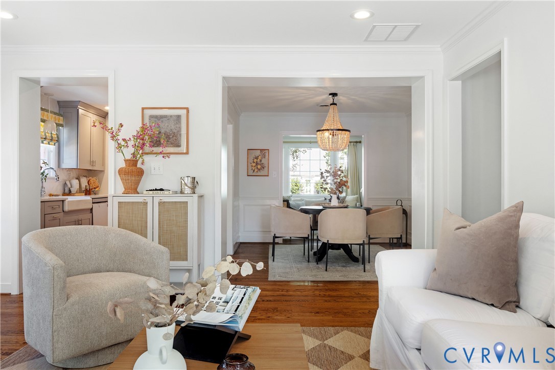 Hardwood flooring throughout, recessed lighting, crown molding, and a beaded chandelier
